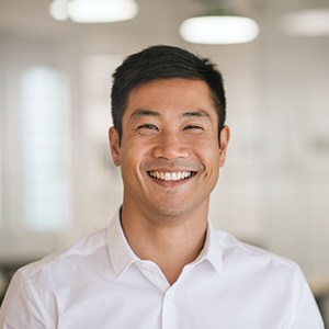 Man in white button-up shirt smiling