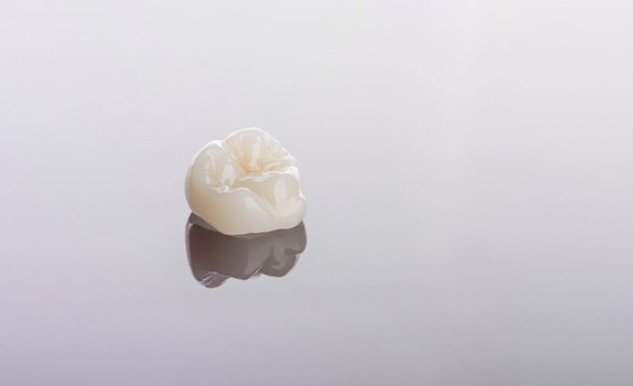 Dental crown resting on reflective surface