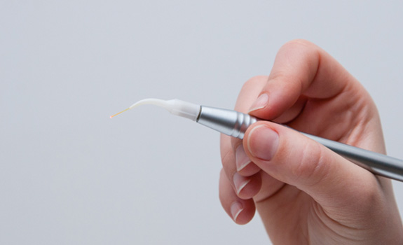 a hand holding a dental laser