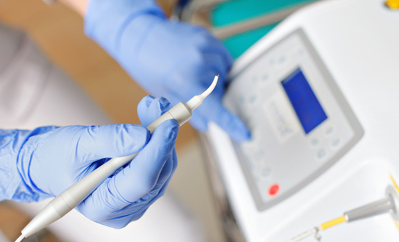 a dentist holding a dental laser