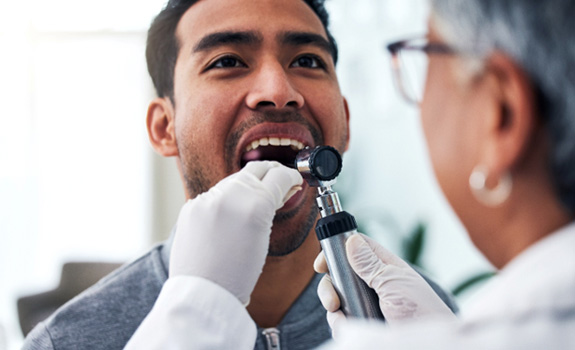 Dentist checking patient’s mouth