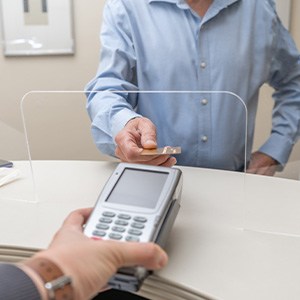 A man using a credit card to pay for his dental care