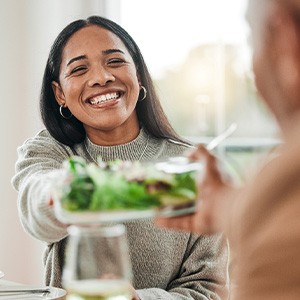 Woman smiling while taking salad bowl