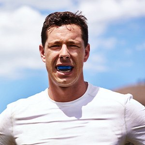 Closeup of man wearing blue mouthguard